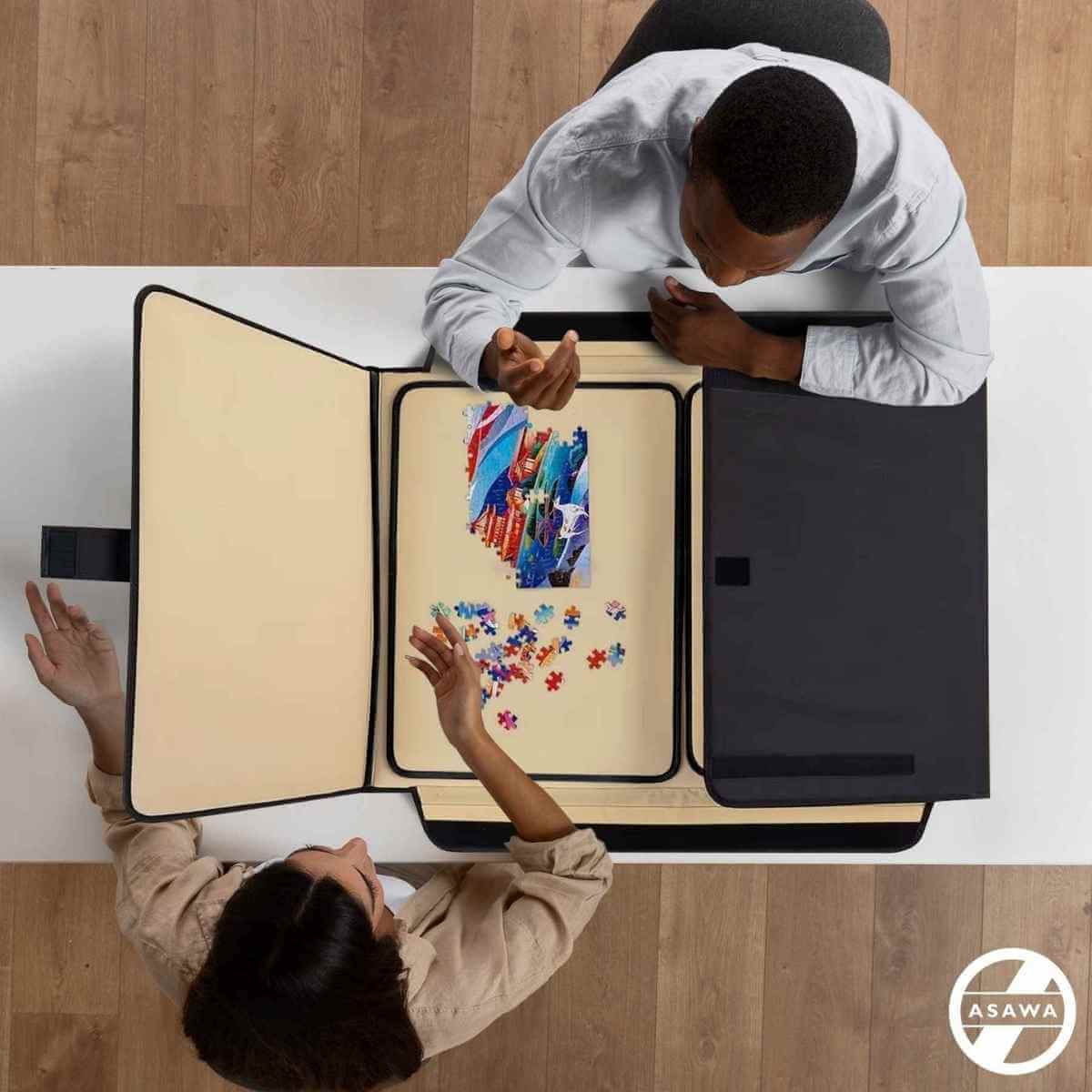 Two people working on a puzzle with a large open book displaying colorful puzzle pieces.