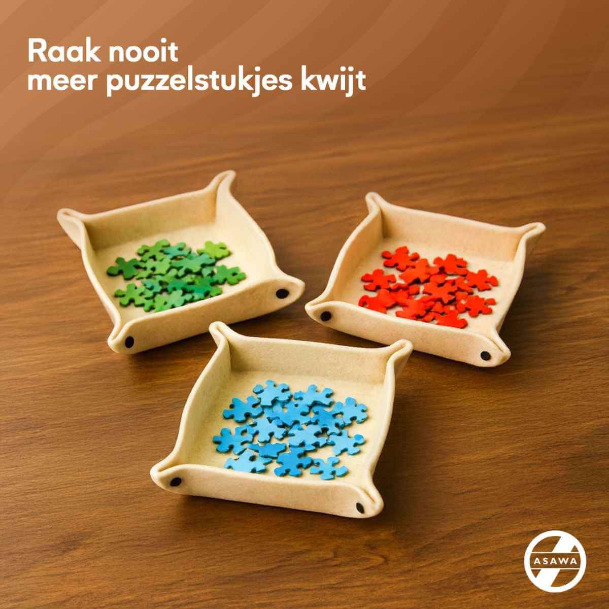 Drie vilten puzzelsorteerbakjes in verschillende kleuren met puzzelstukjes, ideaal voor gestructureerd puzzelen.